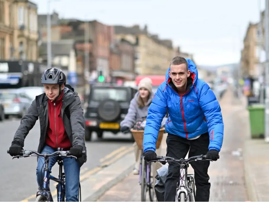 Cyclists riding along a busy Glasgow street on World Bicycle Day 2026, highlighting road safety and the need to reduce cycling accidents.
