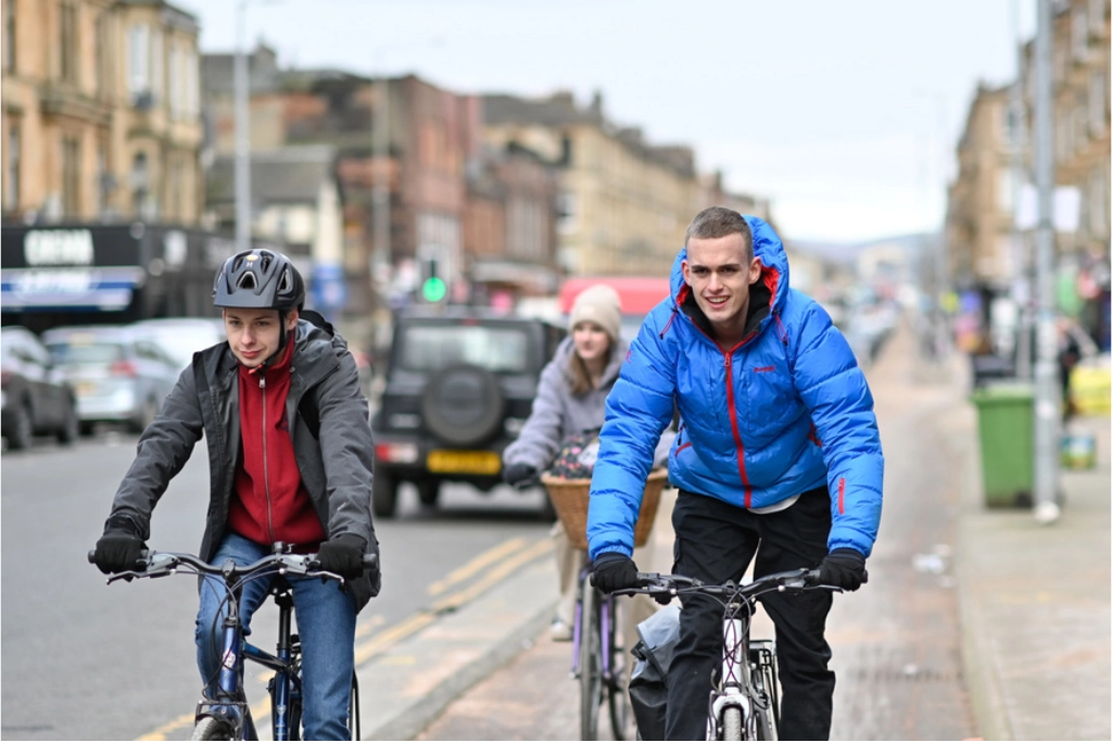 Cyclists riding along a busy Glasgow street on World Bicycle Day 2026, highlighting road safety and the need to reduce cycling accidents.