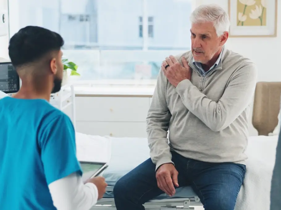 Patient discussing a shoulder injury with a healthcare professional after an accident in Scotland. An image advertising personal injury firm Gildeas Solicitors office. They specialise in accident claims in Scotland, including road traffic accidents, motorcycle accidents, cycling accidents, and accidents at work. They are a no win no fee solicitors.