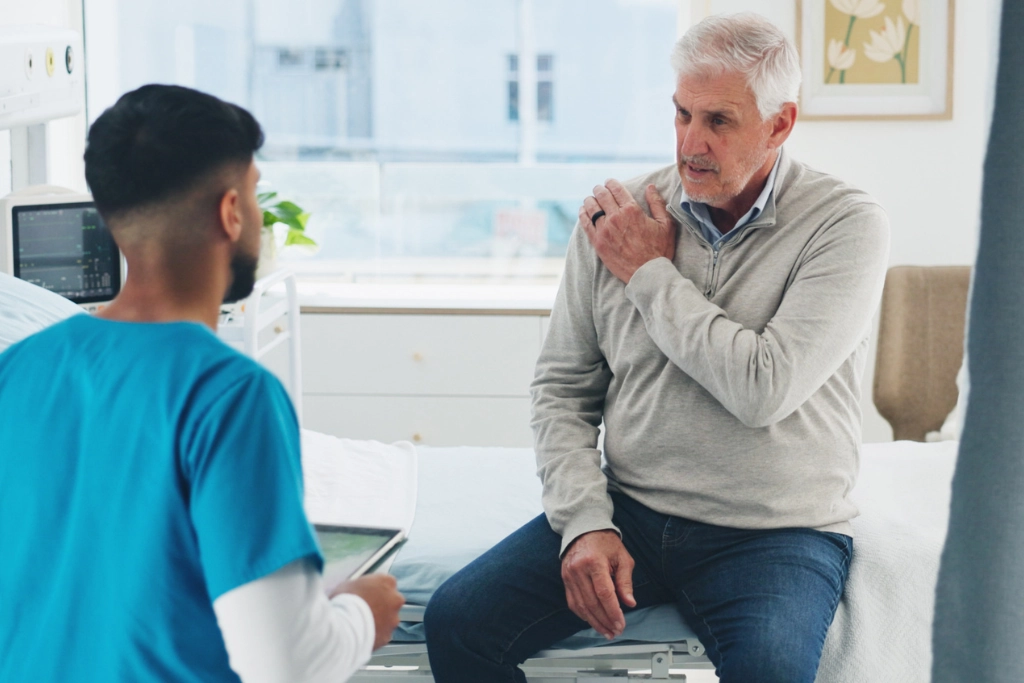 Patient discussing a shoulder injury with a healthcare professional after an accident in Scotland. An image advertising personal injury firm Gildeas Solicitors office. They specialise in accident claims in Scotland, including road traffic accidents, motorcycle accidents, cycling accidents, and accidents at work. They are a no win no fee solicitors.