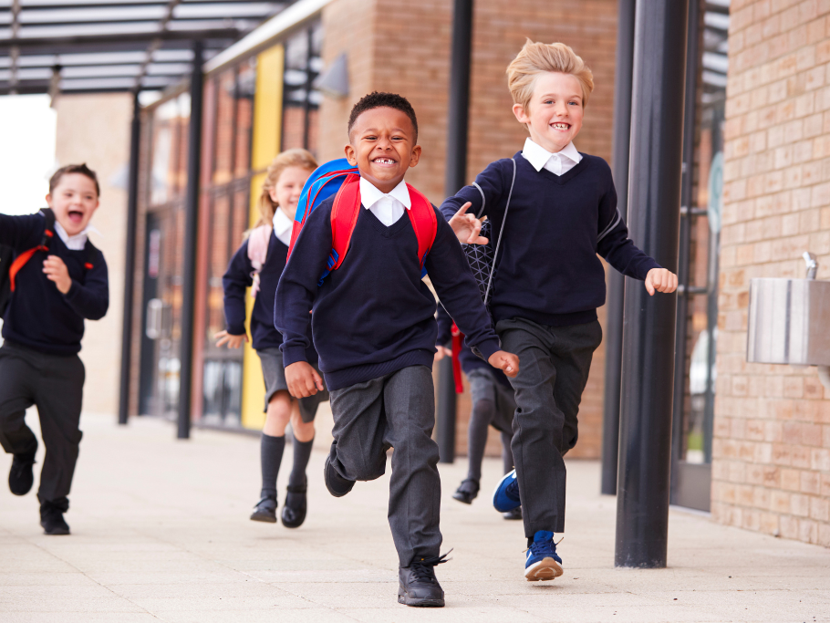 Children running towards school during the back to school period as traffic passes nearby. This could lead to contributory negligence