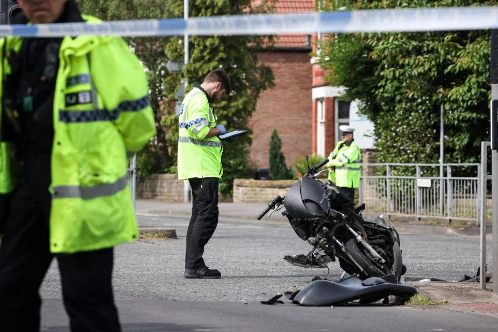 Police officers investigate a motorbike accident on a residential road, with a damaged motorbike and debris visible at the roadside. Gildeas Solicitors supports injured motorcyclists following serious road accidents.
